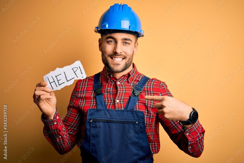 Young builder man wearing safety helmet offering help and support over yellow background with surprise face pointing finger to himself Young builder man wearing safety helmet offering help and support over yellow background with surprise face pointing finger to himself