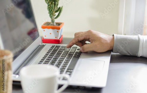 Close up of a .hands business person using a laptop computer to work at home