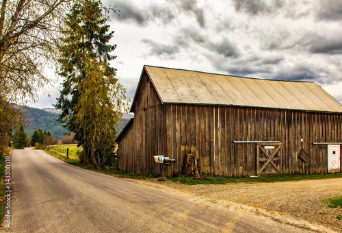 Barn by road with cloudy sky background