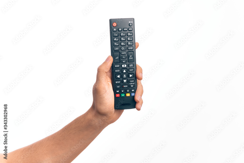 Hand of caucasian young man changing tv channel holding remote control over isolated white background Hand of caucasian young man changing tv channel holding remote control over isolated white background