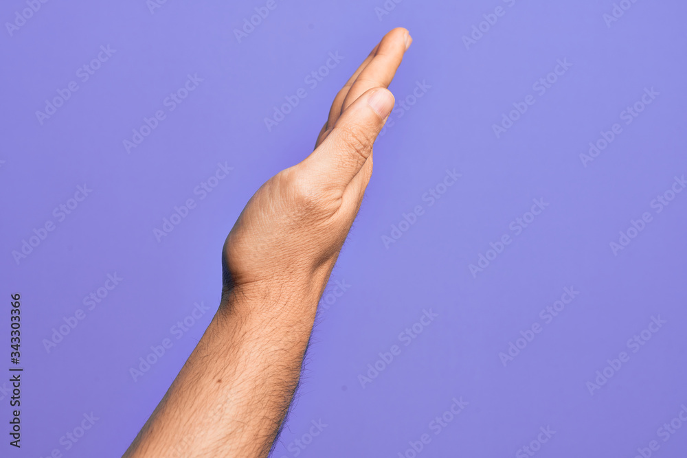 Hand of caucasian young man showing fingers over isolated purple background showing the side of stretched hand, pushing and doing stop gesture
