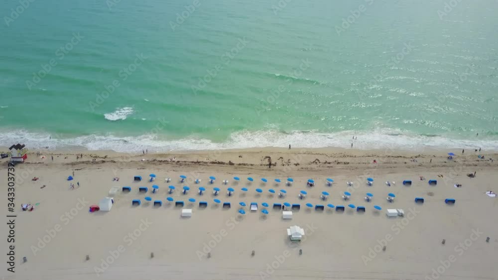Tilt Up Aerial View of Miami Beach. Florida USA. White Sand, Parasols and Turquoise Ocean Water Tilt Up Aerial View of Miami Beach. Florida USA. White Sand, Parasols and Turquoise Ocean Water