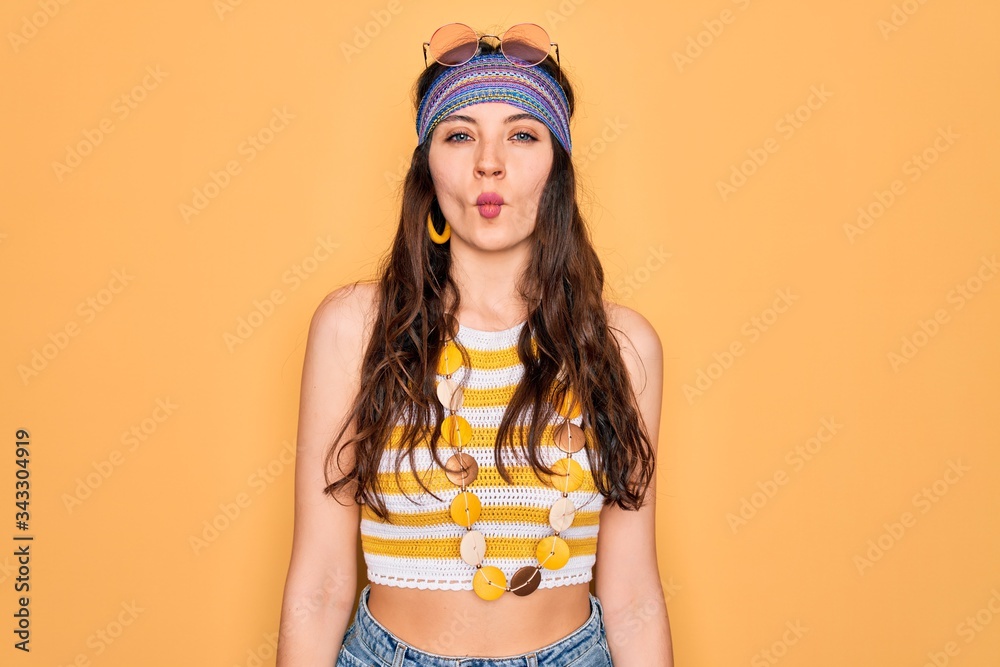 Young beautiful hippie woman with blue eyes wearing accesories and sunnglasses making fish face with lips, crazy and comical gesture. Funny expression. Young beautiful hippie woman with blue eyes wearing accesories and sunnglasses making fish face with lips, crazy and comical gesture. Funny expression.