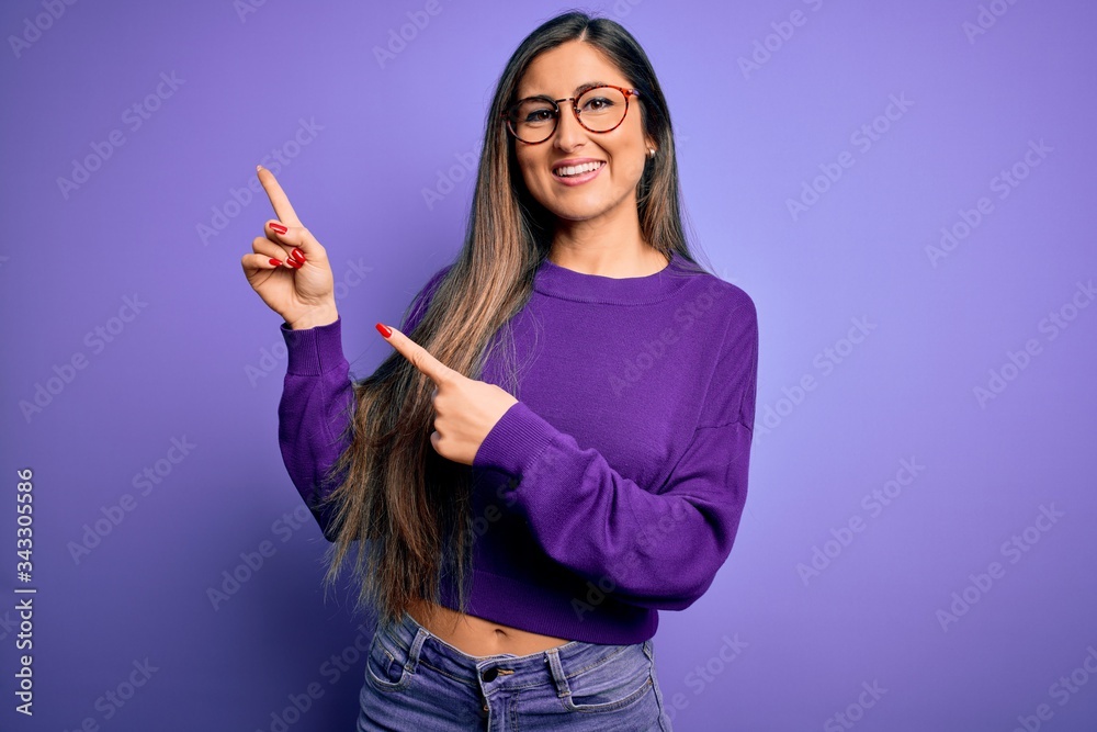 Young beautiful smart woman wearing glasses over purple isolated background smiling and looking at the camera pointing with two hands and fingers to the side. Young beautiful smart woman wearing glasses over purple isolated background smiling and looking at the camera pointing with two hands and fingers to the side.
