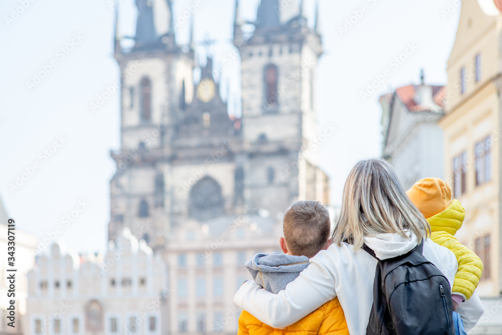 Happy family stands on the Old Town Square in Prague. Empty space for text