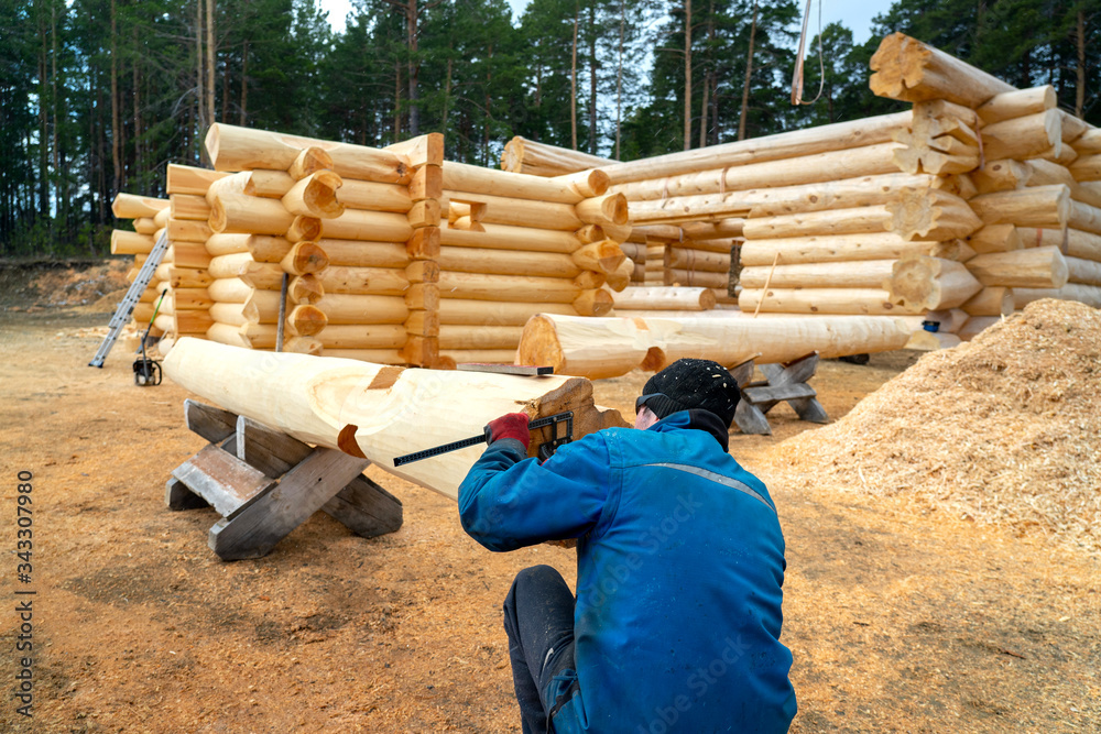 Build a house from logs. Preparation of logs for the assembly of the structure. Assembly of a wooden log house at a construction base Build a house from logs. Preparation of logs for the assembly of the structure. Assembly of a wooden log house at a construction base