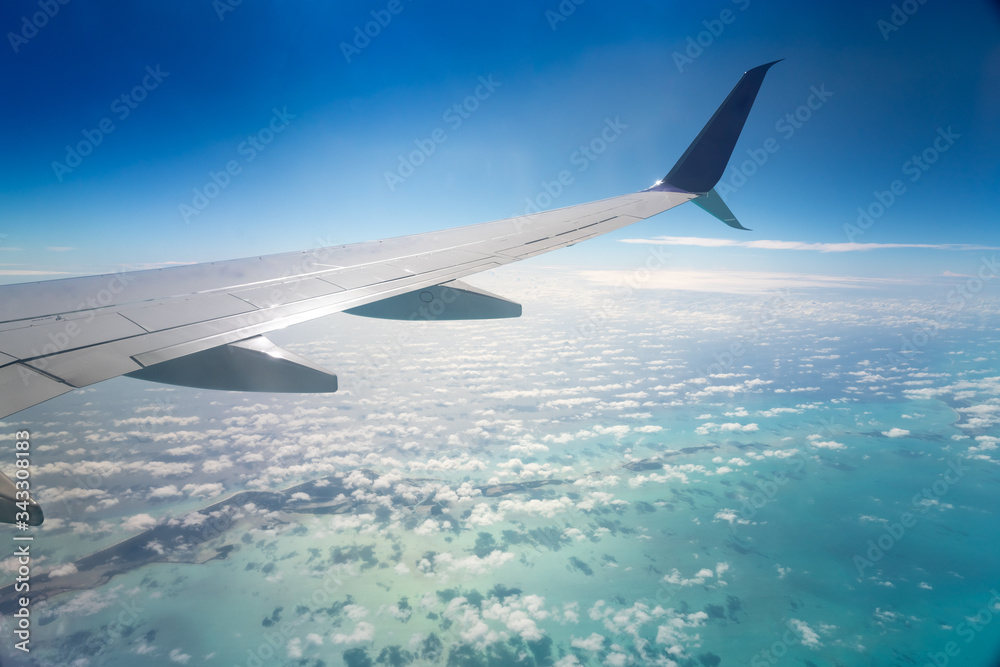 View of the wing of an airplane over the sea with an island. Cuba View of the wing of an airplane over the sea with an island. Cuba