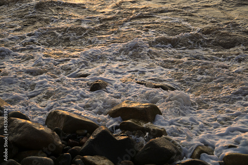 Espuma del mar de mazatlan chocando con las rocas y la arena photo