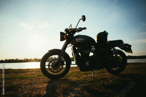 Fototapeta Naklejka Na Ścianę i Meble -  A motorcycle on the road with sunset light background