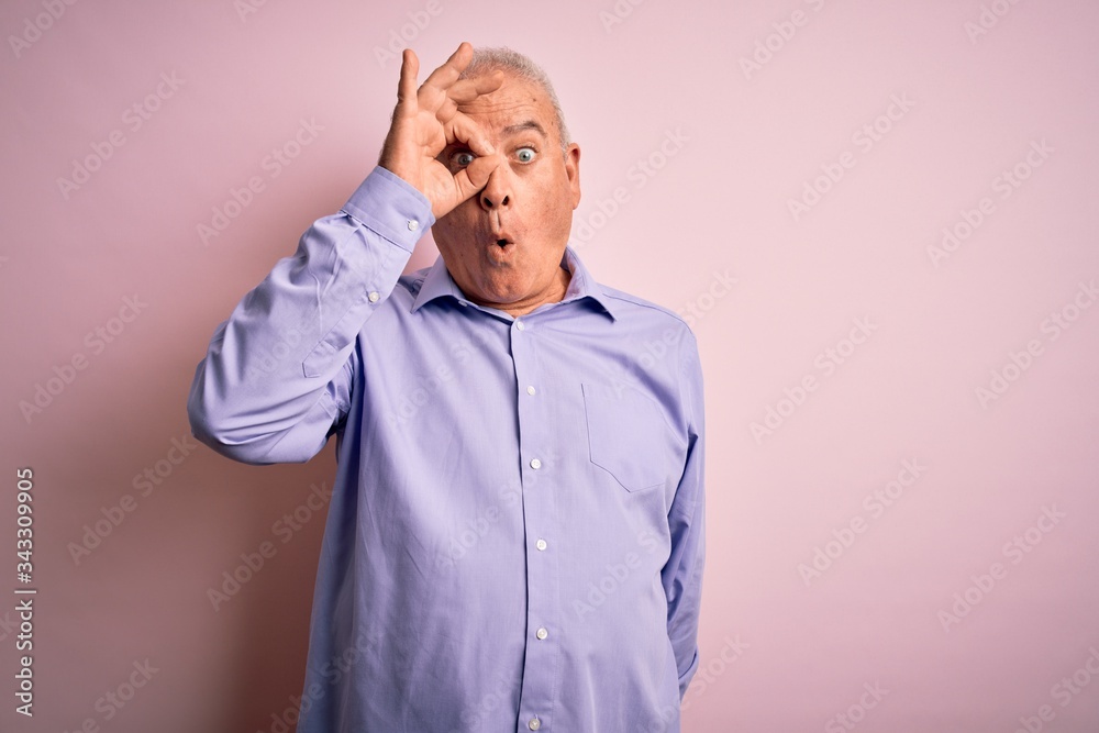 Middle age handsome hoary man wearing casual shirt standing over pink background doing ok gesture shocked with surprised face, eye looking through fingers. Unbelieving expression. Middle age handsome hoary man wearing casual shirt standing over pink background doing ok gesture shocked with surprised face, eye looking through fingers. Unbelieving expression.