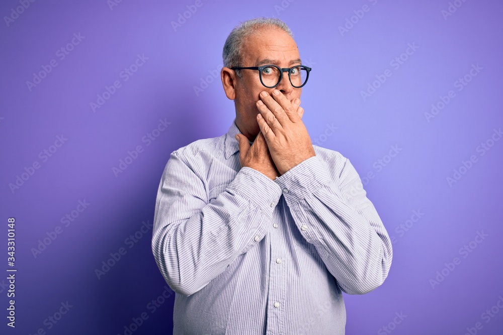 Middle age handsome hoary man wearing striped shirt and glasses over purple background shocked covering mouth with hands for mistake. Secret concept. Middle age handsome hoary man wearing striped shirt and glasses over purple background shocked covering mouth with hands for mistake. Secret concept.