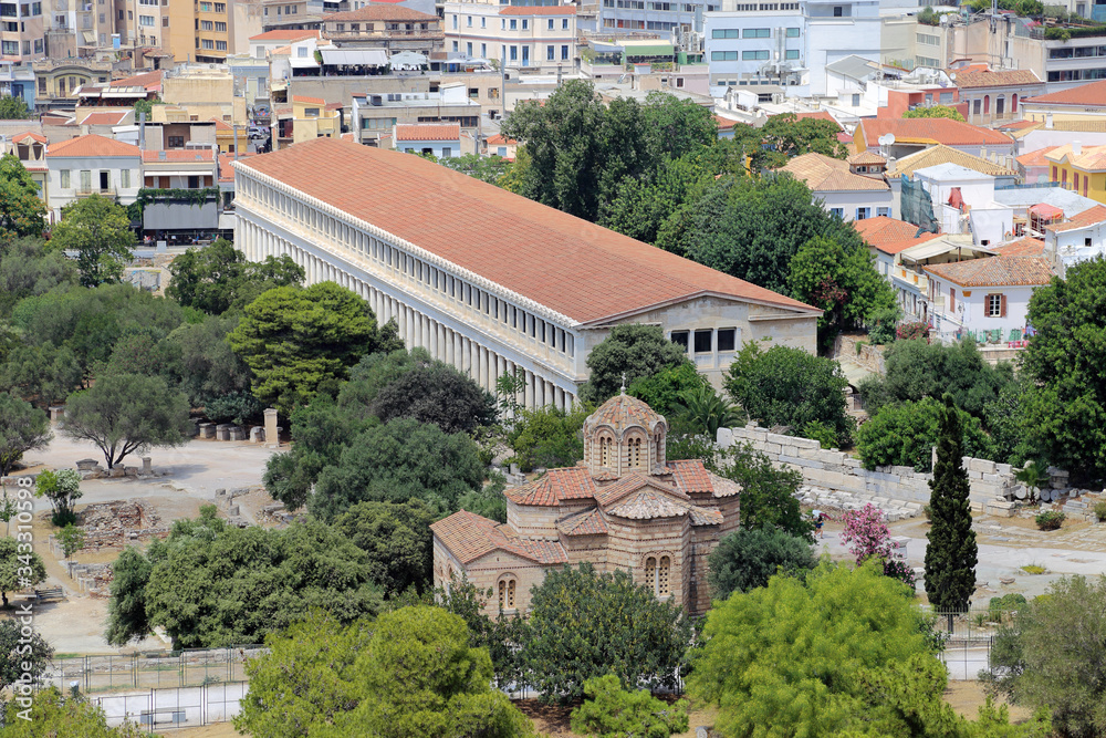 The Stoa of Attalos structure in Athens, Greece, which was an ancient market and reconstructed in the 1950s, is shown during a summer day, located just beyond the Church of the Holy Aspo