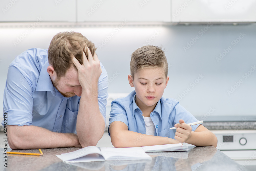 Sad man and his son doing homework together at home Sad man and his son doing homework together at home
