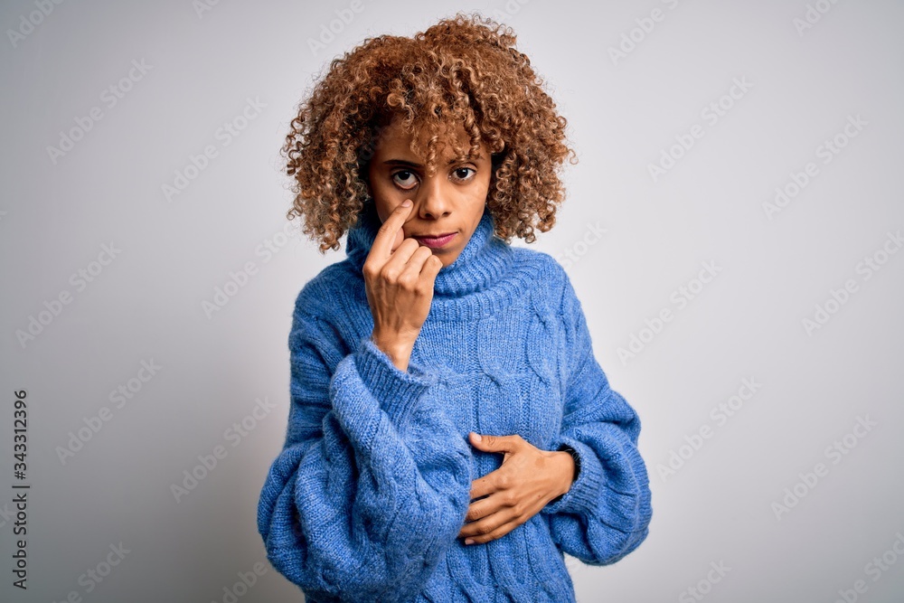 Young beautiful african american woman wearing turtleneck sweater over white background Pointing to the eye watching you gesture, suspicious expression Young beautiful african american woman wearing turtleneck sweater over white background Pointing to the eye watching you gesture, suspicious expression