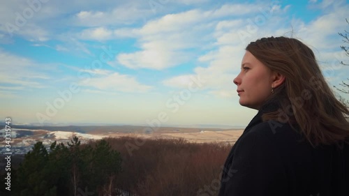 Close-up of a blond girl looking out over a mountain view photo