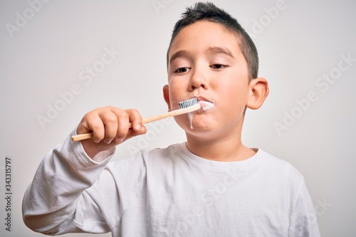 Young little kid boy brushing her teeth using tooth brush and oral paste, cleaning teeth and tongue as healthy health care morning routine. Learning dental education