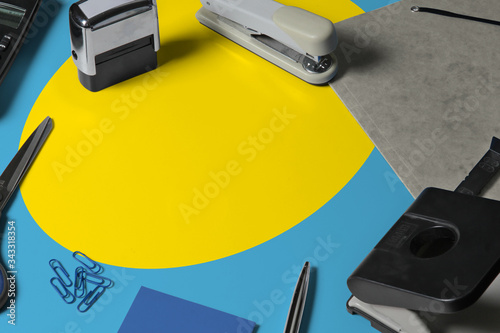 Palau flag with office clerk workplace background. National stationary concept with office tools. photo