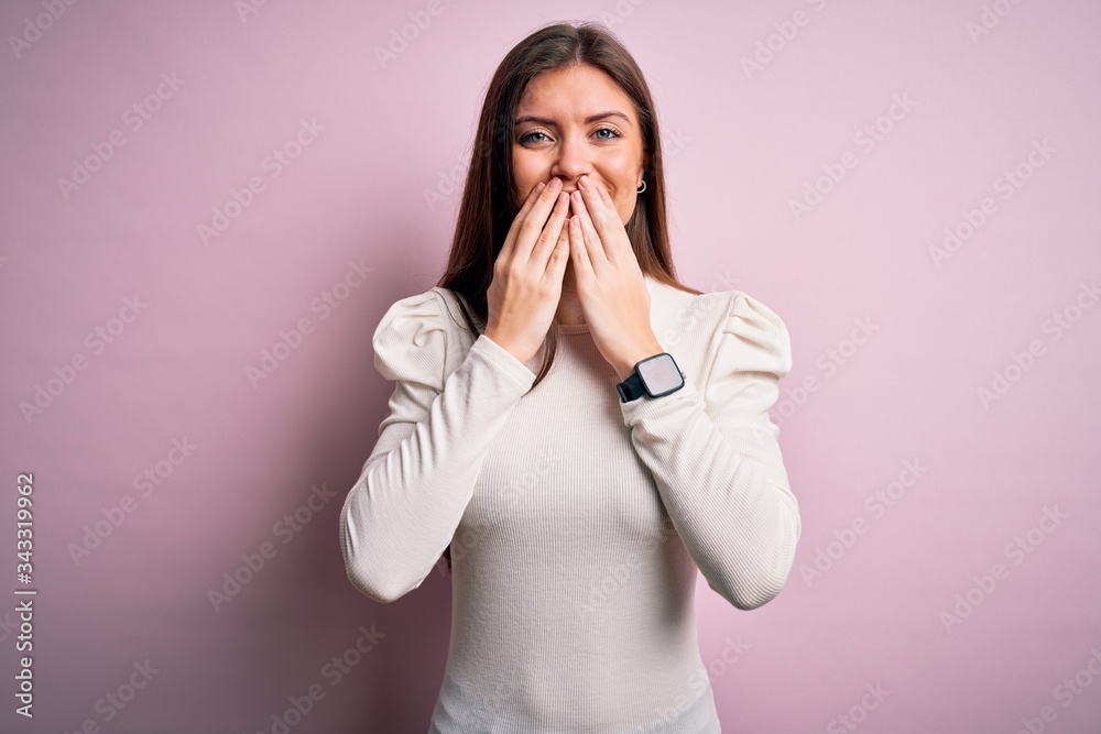 Young beautiful woman with blue eyes wearing casual white t-shirt over pink background laughing and embarrassed giggle covering mouth with hands, gossip and scandal concept Young beautiful woman with blue eyes wearing casual white t-shirt over pink background laughing and embarrassed giggle covering mouth with hands, gossip and scandal concept