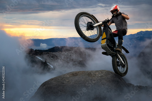 Papier peint Extreme Adventure Man Motorcycle trials on top of a rock