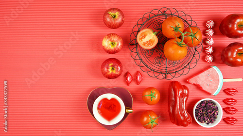 Red foods including apples, tomatoes, cranberry, watermelon, and red rose tea, with powerful healthy antioxidants, lycopene, anthocyanins, vitamin C. Creative concept flatlay with negative copy space.