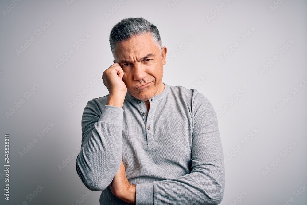 Middle age handsome grey-haired man wearing casual t-shirt over white background thinking looking tired and bored with depression problems with crossed arms. Middle age handsome grey-haired man wearing casual t-shirt over white background thinking looking tired and bored with depression problems with crossed arms.