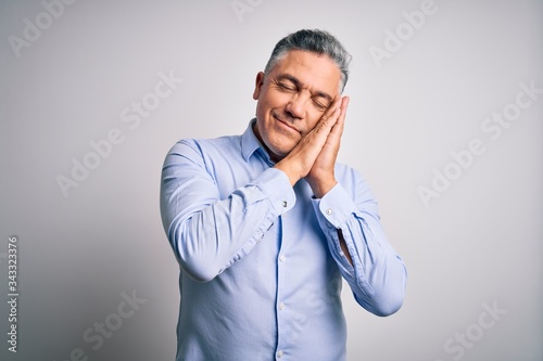 Middle age handsome grey-haired business man wearing elegant shirt over white background sleeping tired dreaming and posing with hands together while smiling with closed eyes.