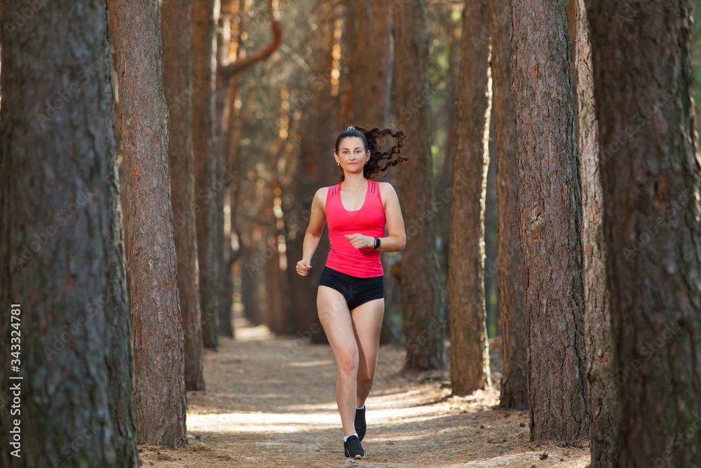 Young woman runner training alone outdoors in the summer forest Young woman runner training alone outdoors in the summer forest