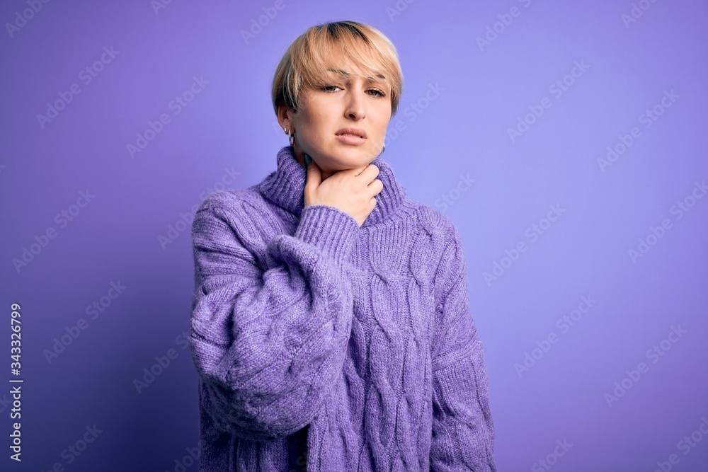 Young blonde woman with short hair wearing winter turtleneck sweater over purple background Touching painful neck, sore throat for flu, clod and infection Young blonde woman with short hair wearing winter turtleneck sweater over purple background Touching painful neck, sore throat for flu, clod and infection