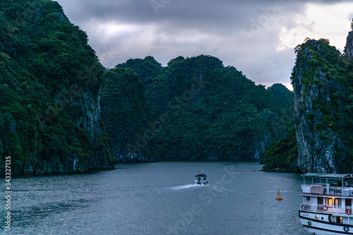 Sunset view of limestone pillars and fisherman boat at Halong, Ha Long Bay, Vietnam