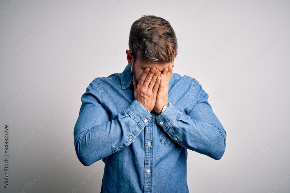 Young handsome blond man with beard and blue eyes wearing casual denim shirt rubbing eyes for fatigue and headache, sleepy and tired expression. Vision problem Young handsome blond man with beard and blue eyes wearing casual denim shirt rubbing eyes for fatigue and headache, sleepy and tired expression. Vision problem