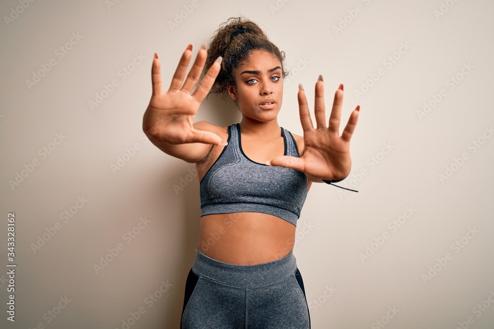 Young african american sportswoman doing sport wearing sportswear over white background doing frame using hands palms and fingers, camera perspective Young african american sportswoman doing sport wearing sportswear over white background doing frame using hands palms and fingers, camera perspective