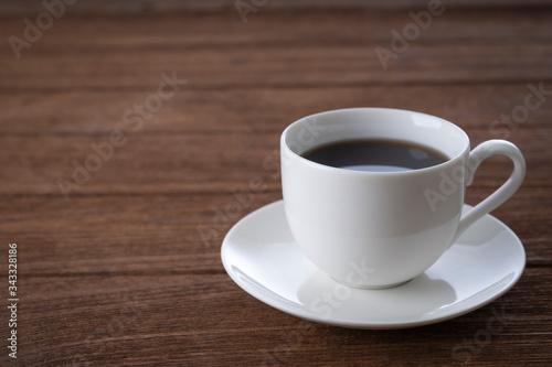 Black coffee in a white mug on the desk