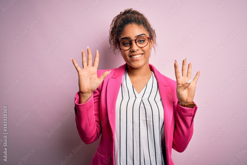 Beautiful african american businesswoman wearing jacket and glasses over pink background showing and pointing up with fingers number nine while smiling confident and happy. Beautiful african american businesswoman wearing jacket and glasses over pink background showing and pointing up with fingers number nine while smiling confident and happy.