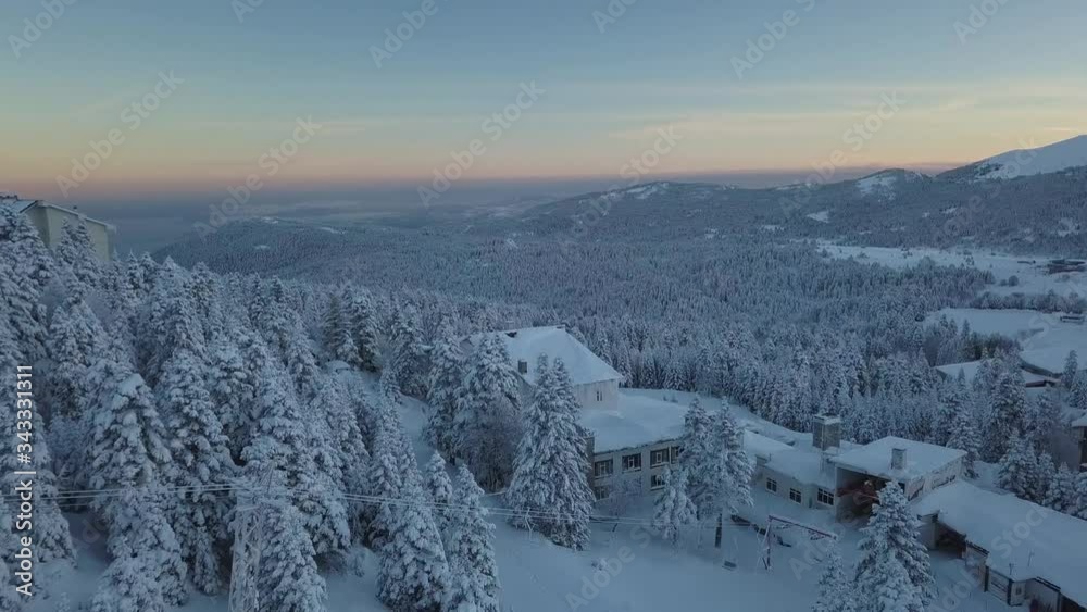 Uludag Mountain, Bursa Province, Turkey. Pull Back Aerial of Winter Landscape and Snow Capped Forest In Twilight