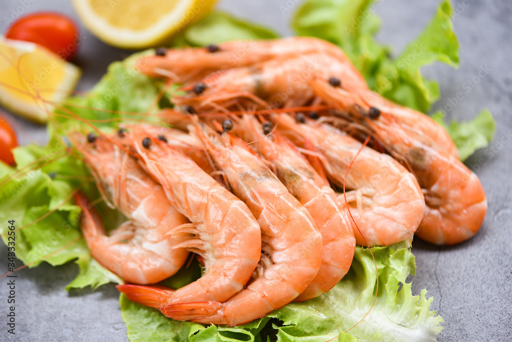 Cooking seafood shrimps prawns served on a table background - fresh shrimp on lettuce salad vegetable with ingredients herb