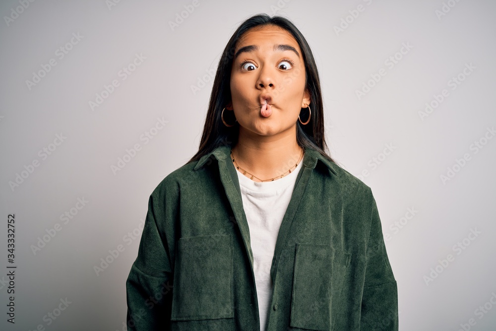 Young beautiful asian woman wearing casual shirt standing over isolated white background making fish face with lips, crazy and comical gesture. Funny expression. Young beautiful asian woman wearing casual shirt standing over isolated white background making fish face with lips, crazy and comical gesture. Funny expression.