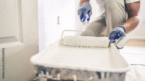 Close Up Shot of White Paint being applied on a Roller.