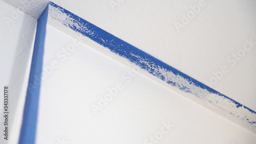Removing masking blue tape from ceiling.