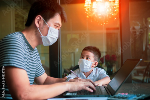 quarantine asian man and children wearing protection mask working on computer at home selected focusing on children face