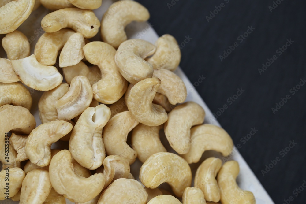 Cashew nuts on a black background.Cashew nut background.Useful fats.Organic bio product.healthy snack and dessert. Cashew nuts on a black background.Cashew nut background.Useful fats.Organic bio product.healthy snack and dessert.