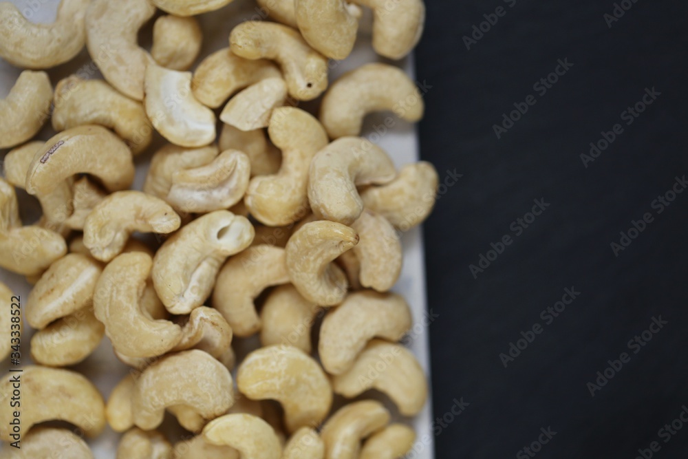Cashew nuts on a black background.Cashew nut background.Useful fats.Organic vegan product.healthy snack and dessert. Cashew nuts on a black background.Cashew nut background.Useful fats.Organic vegan product.healthy snack and dessert.