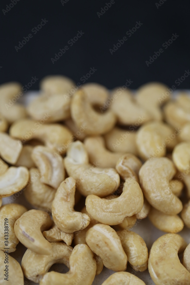 Fototapeta premium Cashew nuts on a black background.Useful fats.Organic vegan bio product.healthy snack and dessert. 