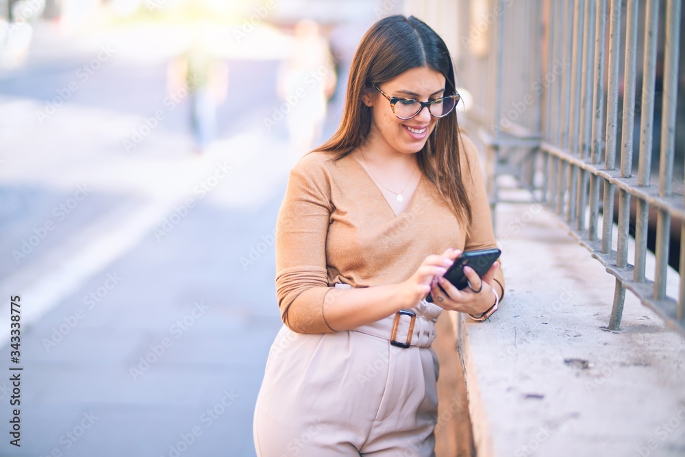 Young beautiful woman smiling happy and confident. Standing with smile on face using smartphone at the city Young beautiful woman smiling happy and confident. Standing with smile on face using smartphone at the city