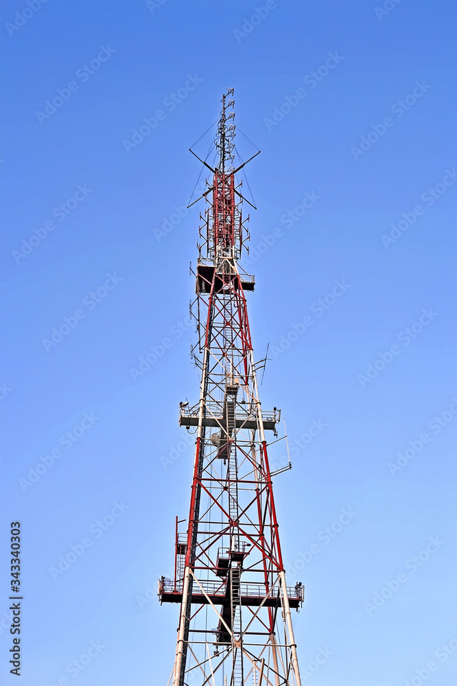 radio, television and mobile antenna tower with jammer aka muffler function on blue sky, telecommenications diversity radio, television and mobile antenna tower with jammer aka muffler function on blue sky, telecommenications diversity