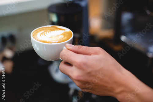 man hand holding a white coffee cup