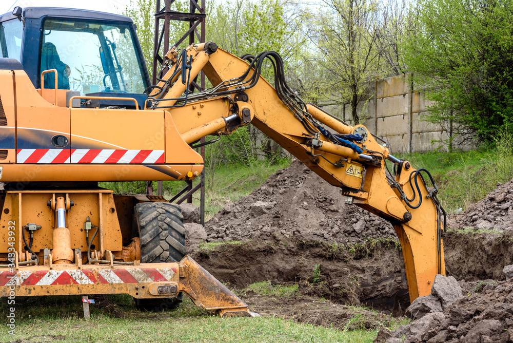 Fototapeta premium The modern excavator performs excavation work on the construction site