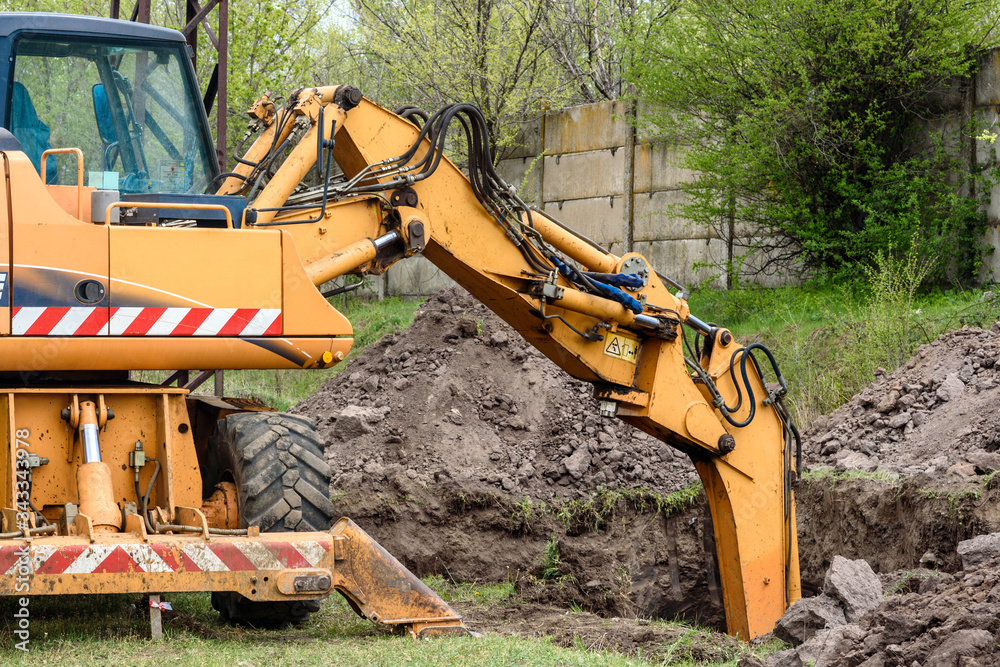 Fototapeta premium The modern excavator performs excavation work on the construction site