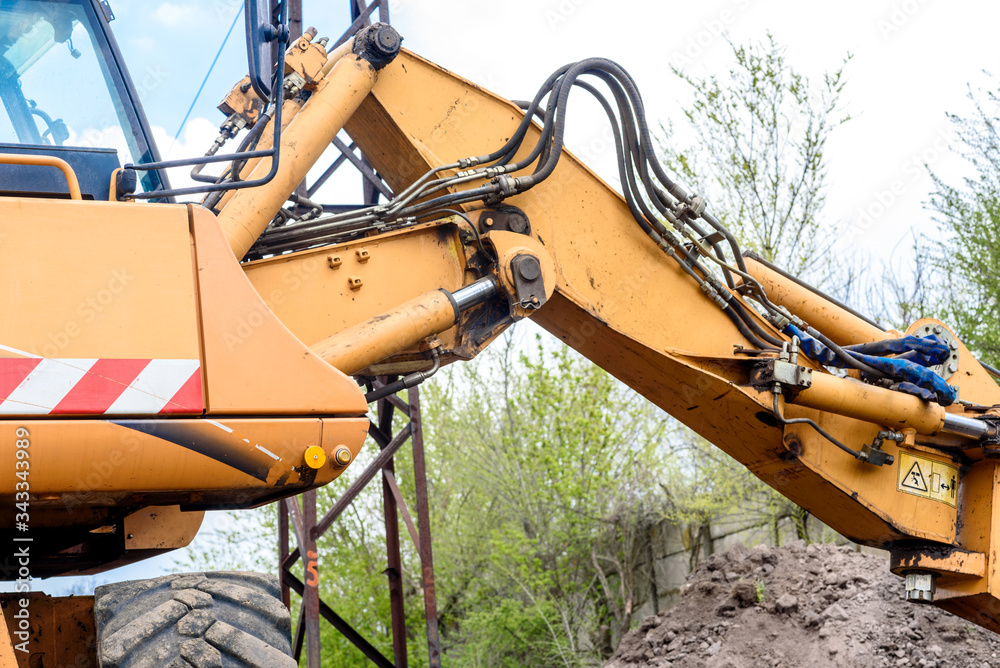 The modern excavator performs excavation work on the construction site The modern excavator performs excavation work on the construction site