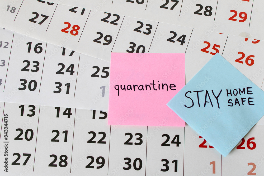 CORONAVIRUS. A sticker with the word quarantine on the calendar sheets. The concept of quarantine. Selective focus. CORONAVIRUS. A sticker with the word quarantine on the calendar sheets. The concept of quarantine. Selective focus.