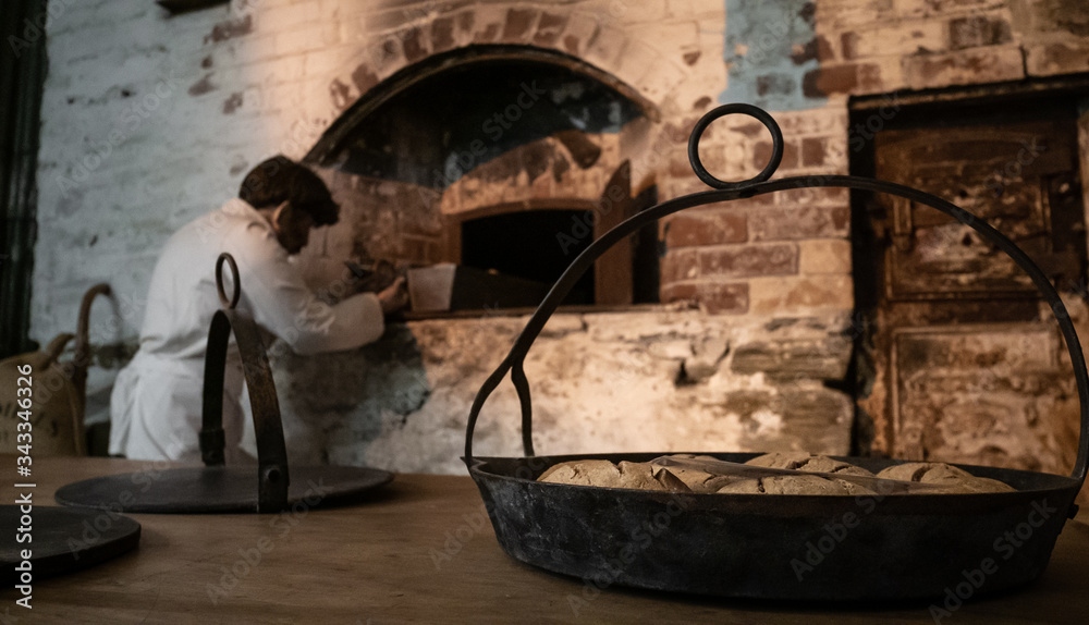 Baker getting ready to bake a bread in old traditional bakery Stock